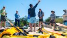 A local Galapagos tour guide talking to a group of sea kayakers before their paddling journey on a sunny day