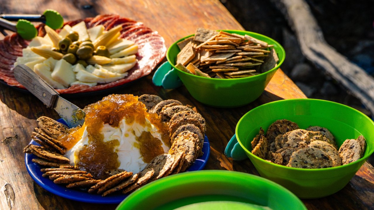 Riverside appetizer spread with cheese, meats, and crackers on a main Salmon River rafting trip.