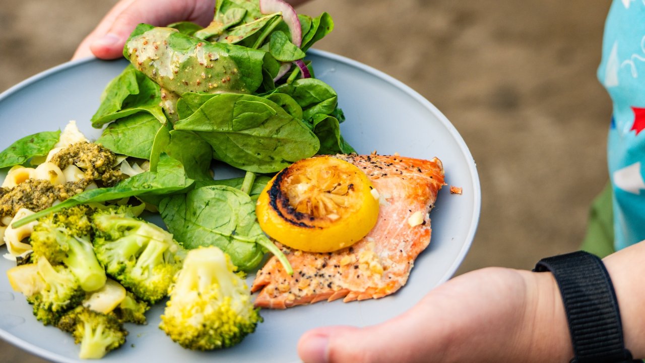 Fresh grilled salmon, pasta, and vegetables served riverside on a Lower Salmon River rafting trip in Idaho’s Salmon River canyons.
