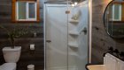 Bathroom with sink, mirror, glass shower, and toilet in one of the cabins at Half Moon Bar Lodge in Oregon