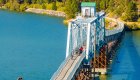 Group of cyclists crossing a steel bridge over a lake on a guided biking tour in Idaho