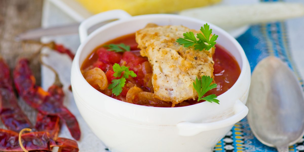  traditional Dalmatian fish stew topped with parsley and an egg in a white bowl