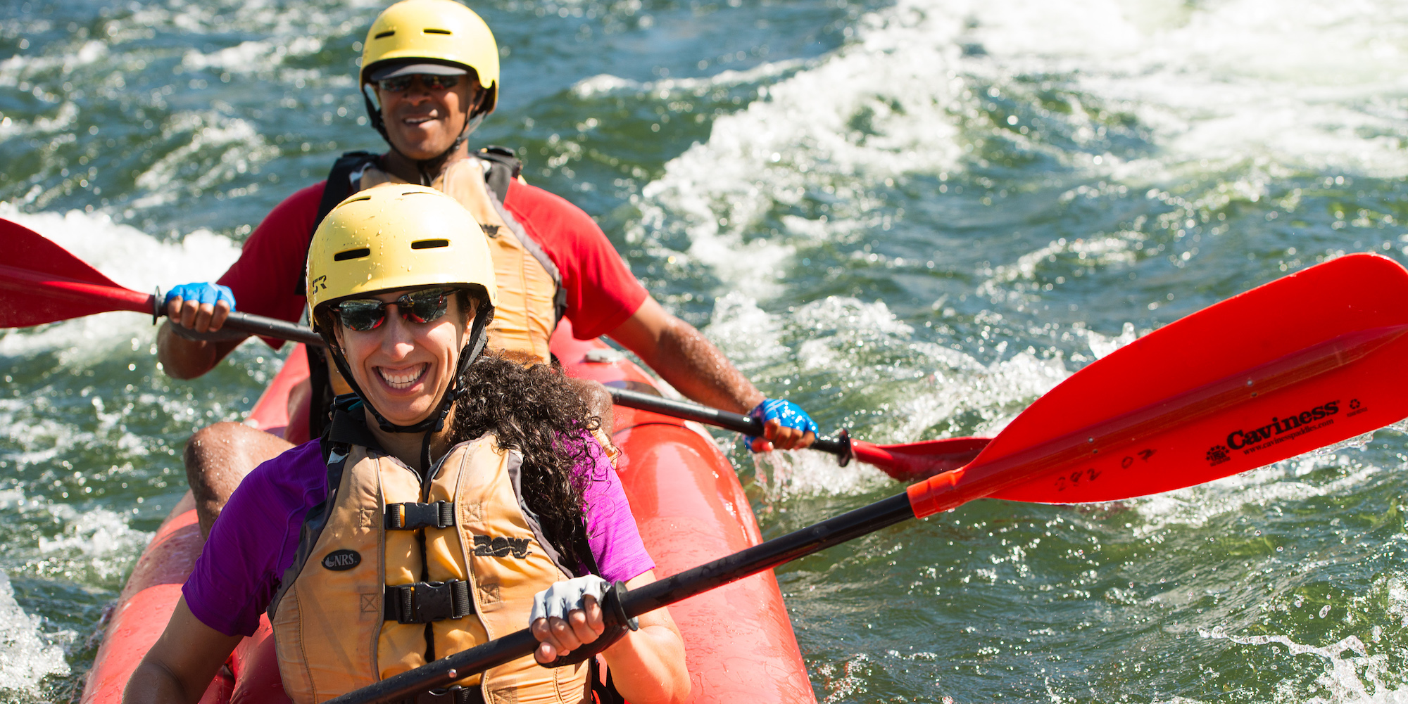 A man and woman in a tandem inflatable kayak