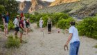 Group of guests on a multi-day rafting trip playing horseshoe at a riverside camp along the Snake River in Idaho
