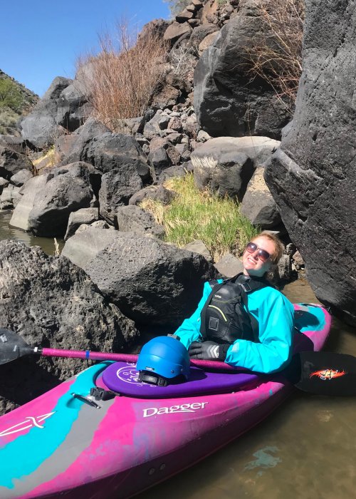 female in pink and blue whitewater kayak