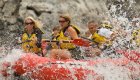 people in whitewater raft getting splashed by water