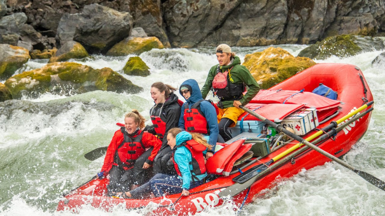 raft in between two rocks going through a rapid on the Snake River through Hells Canyon in Idaho