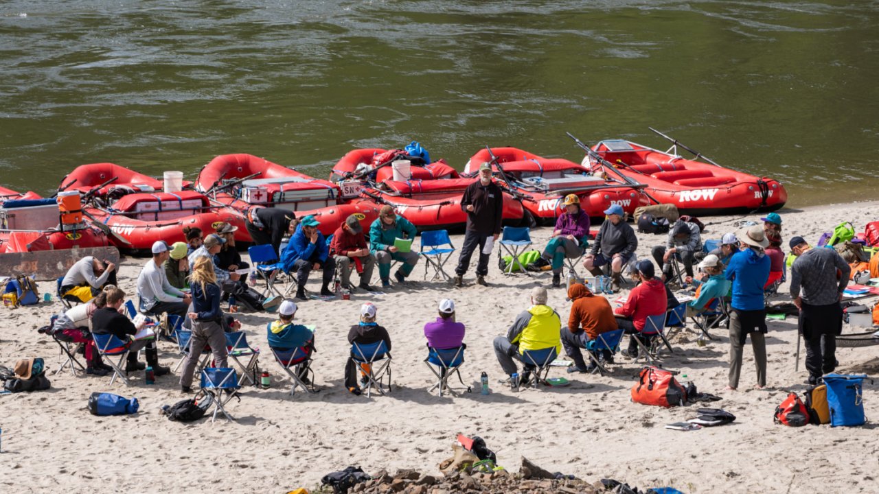rafters sitting in circle on beach