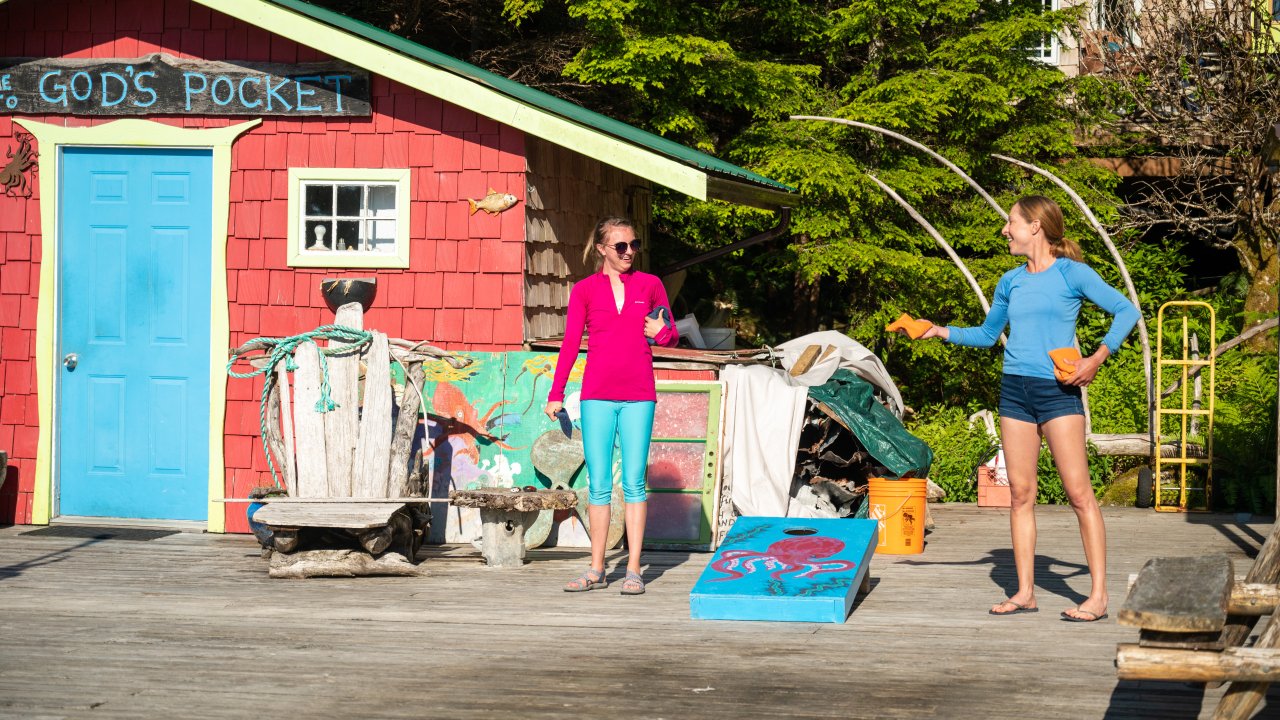 Guests playing corn hole on the deck at God's Pocket Resort