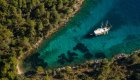 An areal view of a yacht anchored in a secluded cove along the Croatian coastline. 