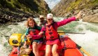 Family rafting through whitewater rapids with a guide in Idaho.