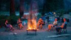 Guests relaxing around a glowing campfire on the banks of the Middle Fork of the Salmon River, enjoying music and wilderness camping in Idaho’s backcountry.