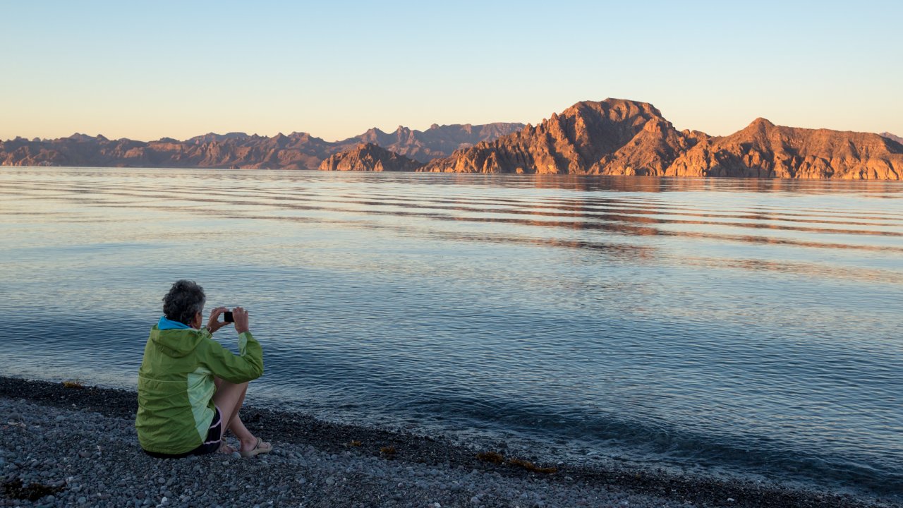 Guest admiring the view of the desert mountains from the beach in Baja, California Sur