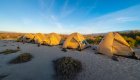Tents set up on a beach in a row at sunset in the Galapagos Islands