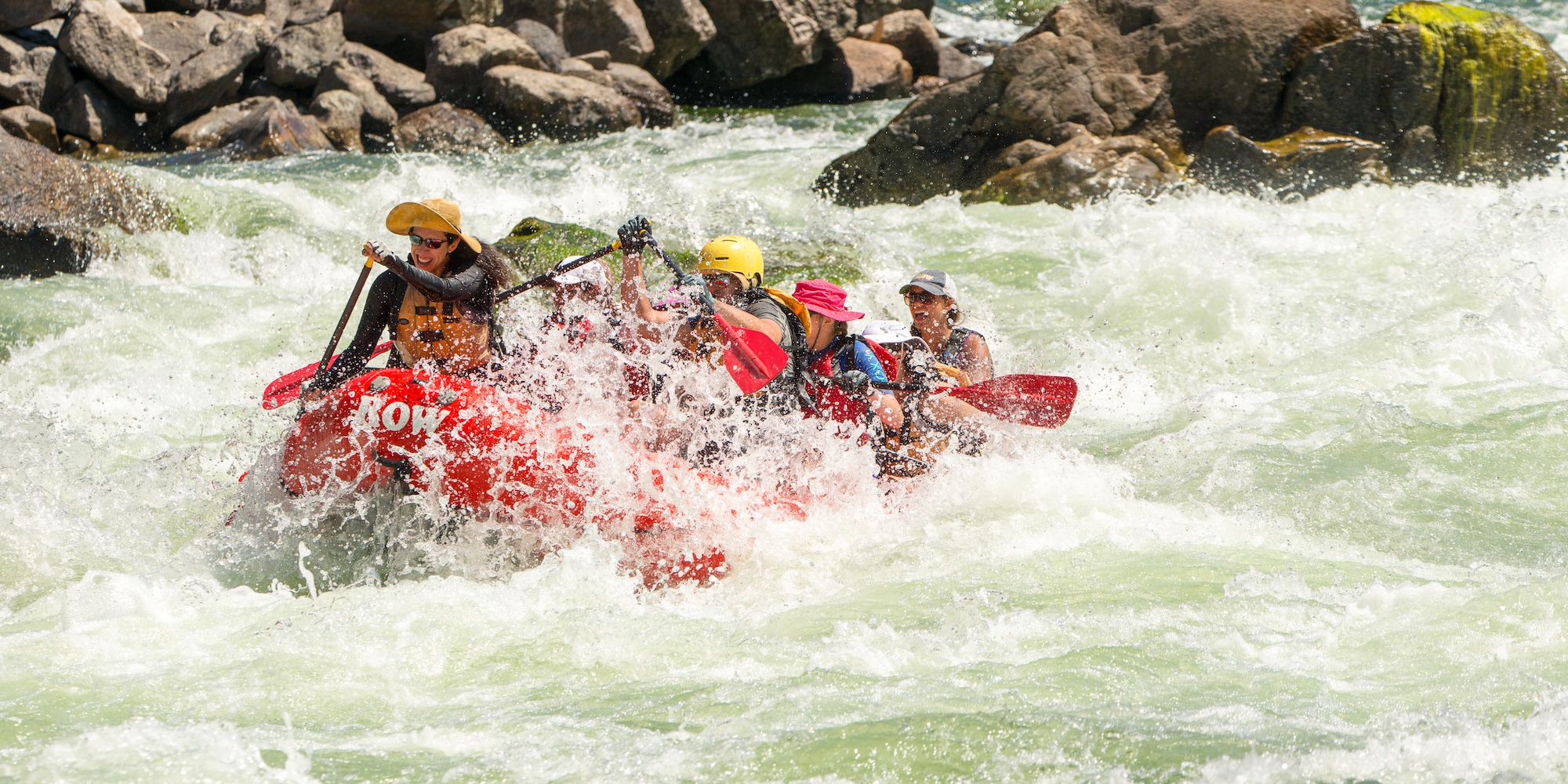 Group of people in a whitewater raft navigating through a splashy section of the Salmon river.