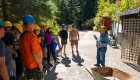 Tour group wearing helmets listens to a guide during an Idaho adventure tour with biking and history experiences.