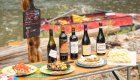 Wine, cheese, and appetizers arranged riverside during a gourmet meal on a Middle Fork Salmon River rafting tour.
