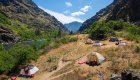 Tent campsite along the Snake River in Hells Canyon, Idaho, surrounded by rugged canyon walls and scenic river views on a whitewater rafting trip.