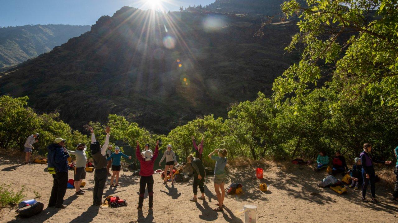 group of people stretching on river bank