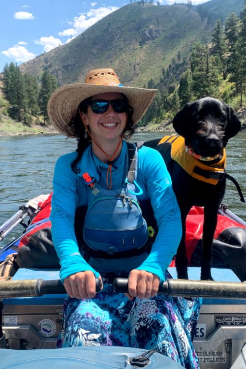 female river guide with dog on raft