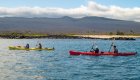 Tandem kayakers paddling off the beach in the Galapagos Islands