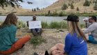 ROW Adventures guide Tom Scarbrough teaching a circle of people how to navigate a raft through a rapid along the Deschutes River