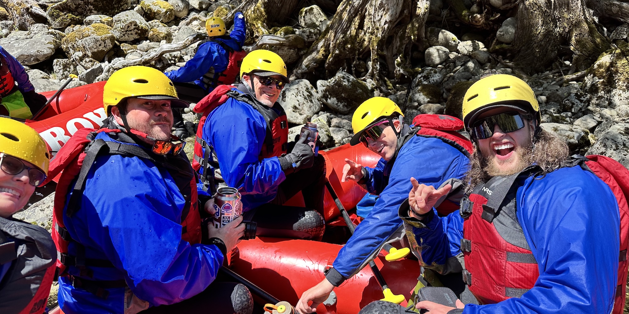 Group of people dressed in blue, yellow, and red rafting gear.