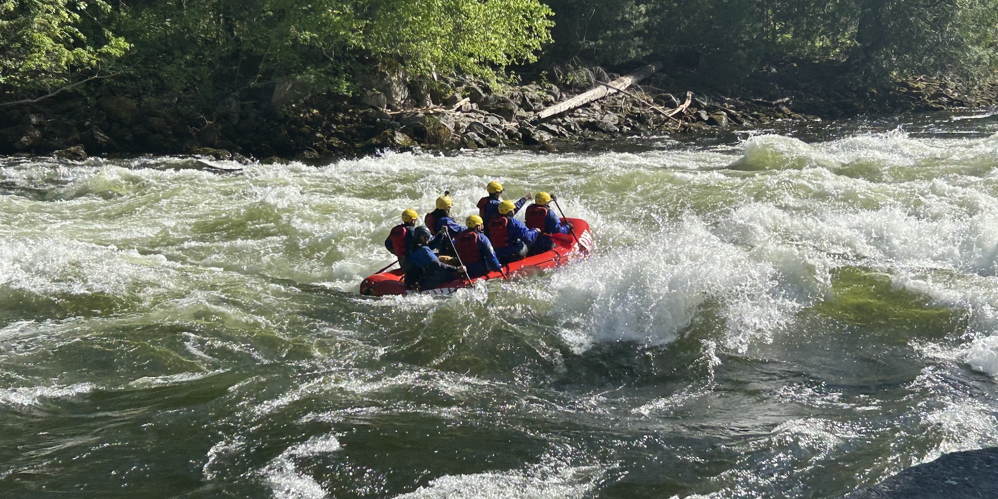 ROW adventures raft navigating through rough whitewater.