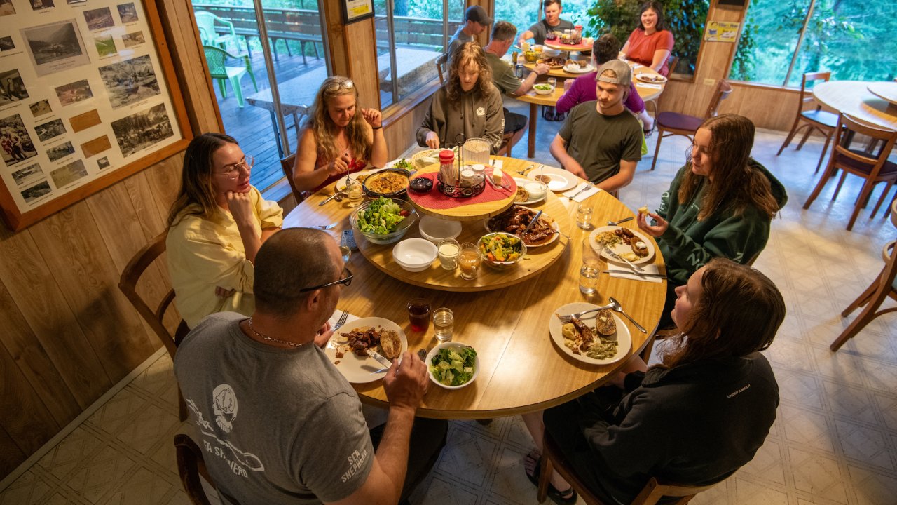 People sitting around a circular table with a lazy suzan in the middle full of food