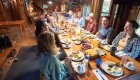 People sitting around a dining room table in a cabin in Oregon