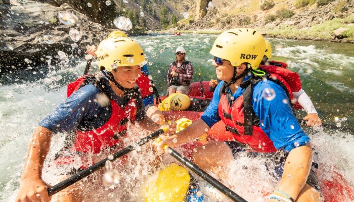 Rafters paddling through whitewater rapids on the Middle Fork of the Salmon River in Idaho during a guided rafting adventure.