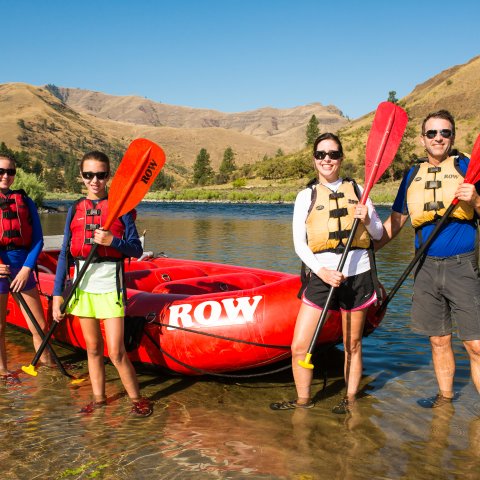 A family of four posing for a photo while rafting the Salmon River in Idaho