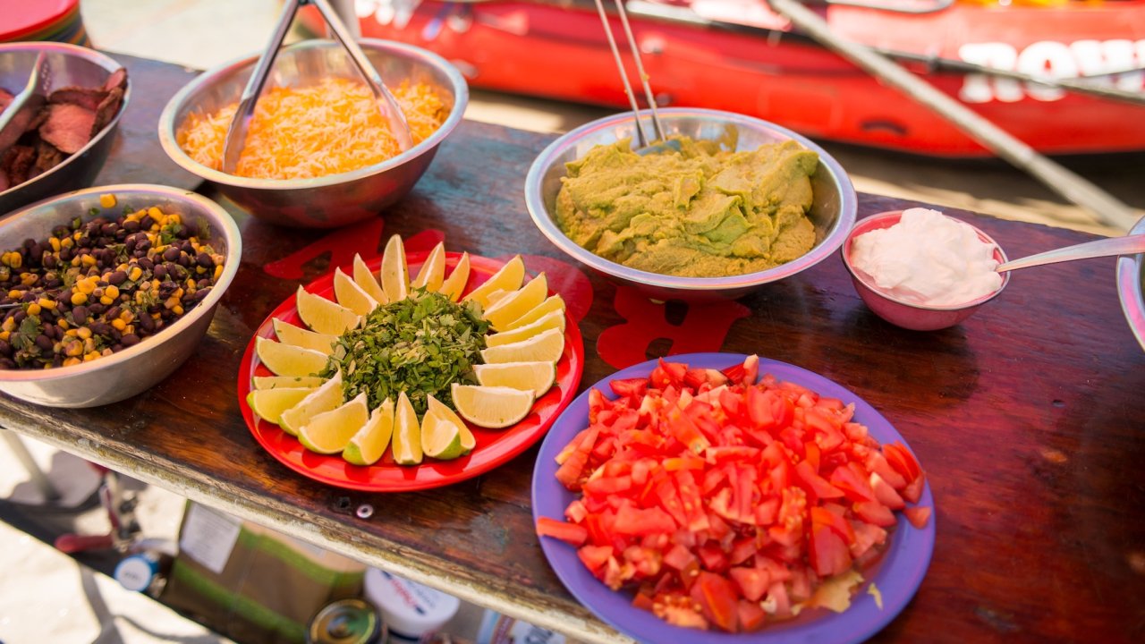 A variety of food displayed on a table at a beach along the Salmon river.