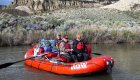 A group of rafters on a ROW Adventures red raft floating down the Owyhee river.