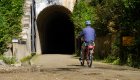A person biking into a tunnel on a sunny day