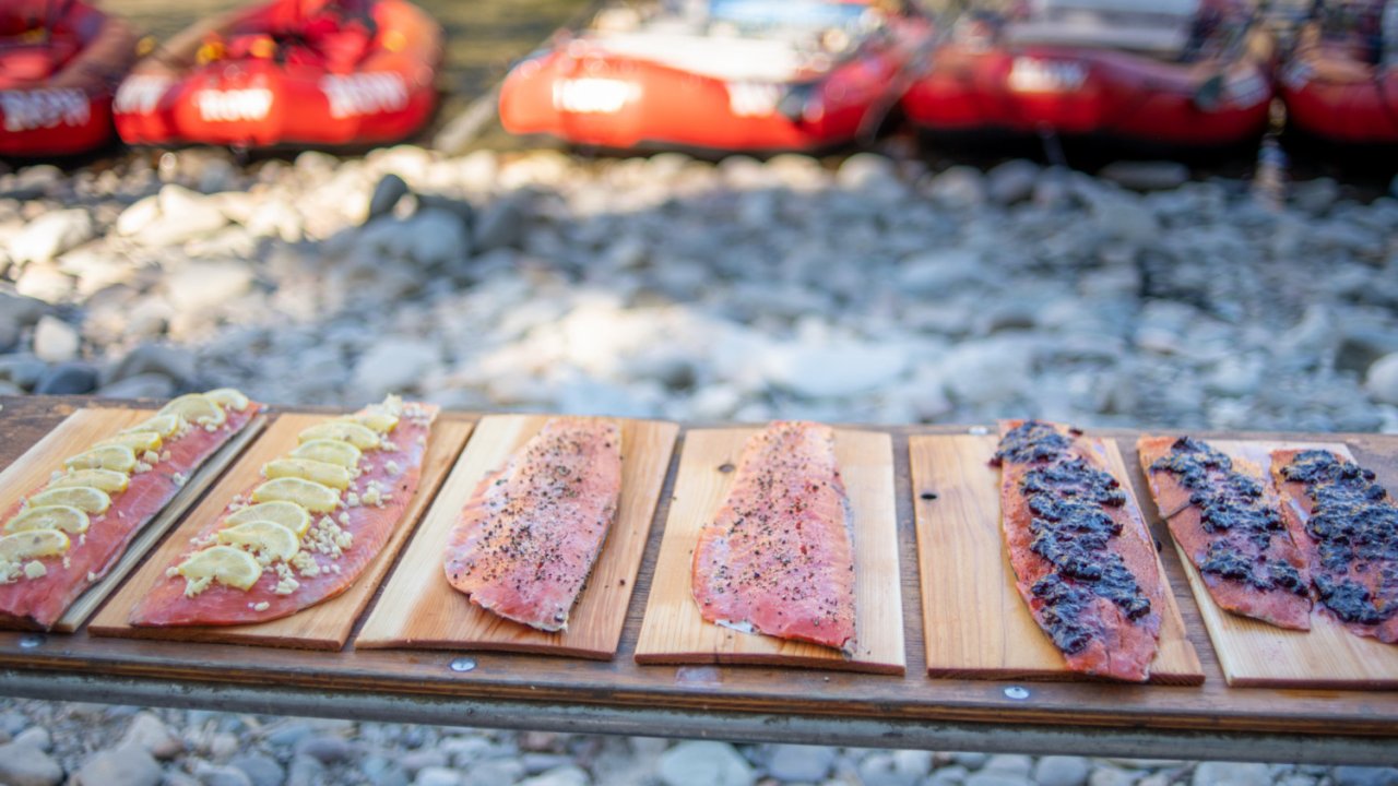 salmon on cedar boards with rafts in the background