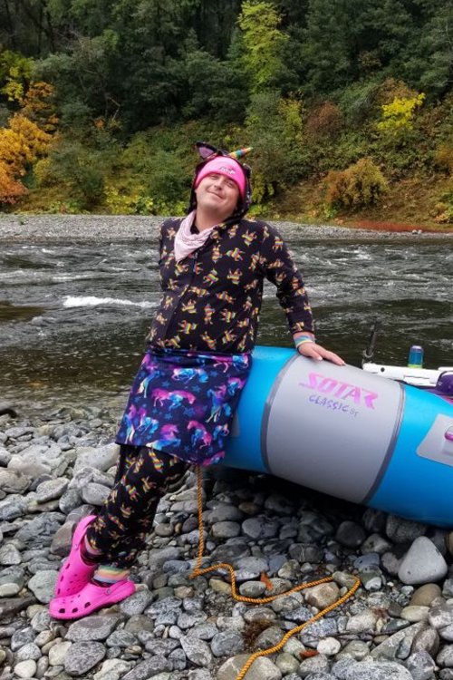 Oregon river guide leaning on blue and grey raft