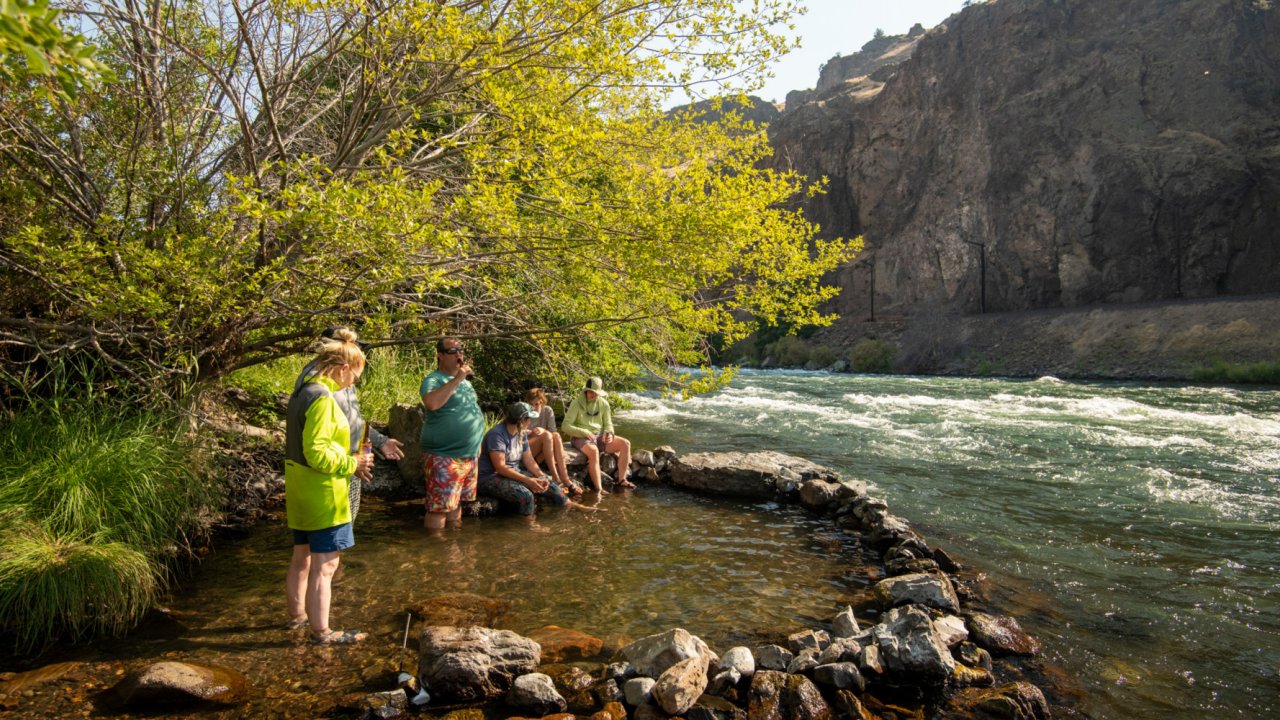 Guests cooling off in a small riverside pool on a hot and sunny day on the Deschutes river