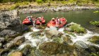 side stream flowing into the Rogue River in Oregon where people stand around red rafts