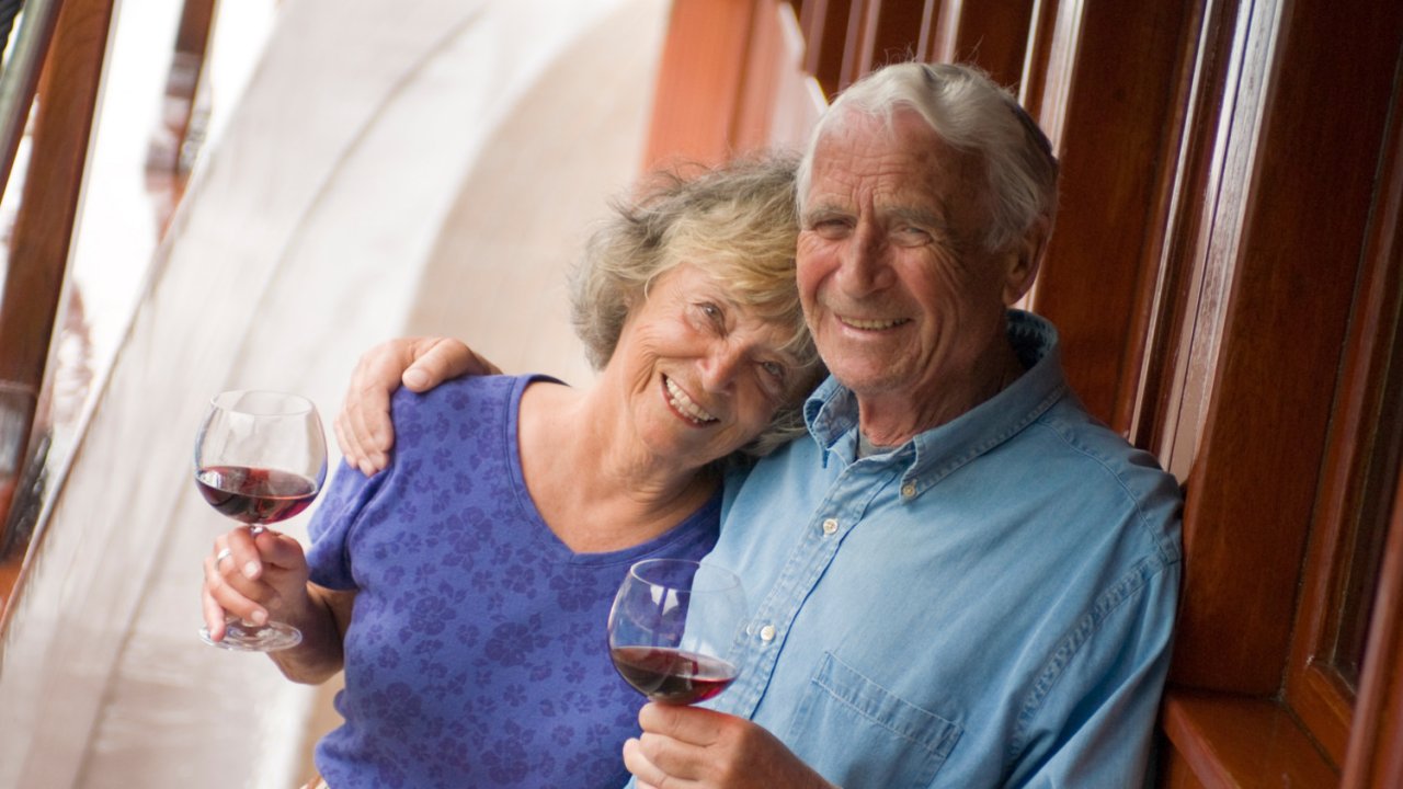 couple on board yacht deck with wine
