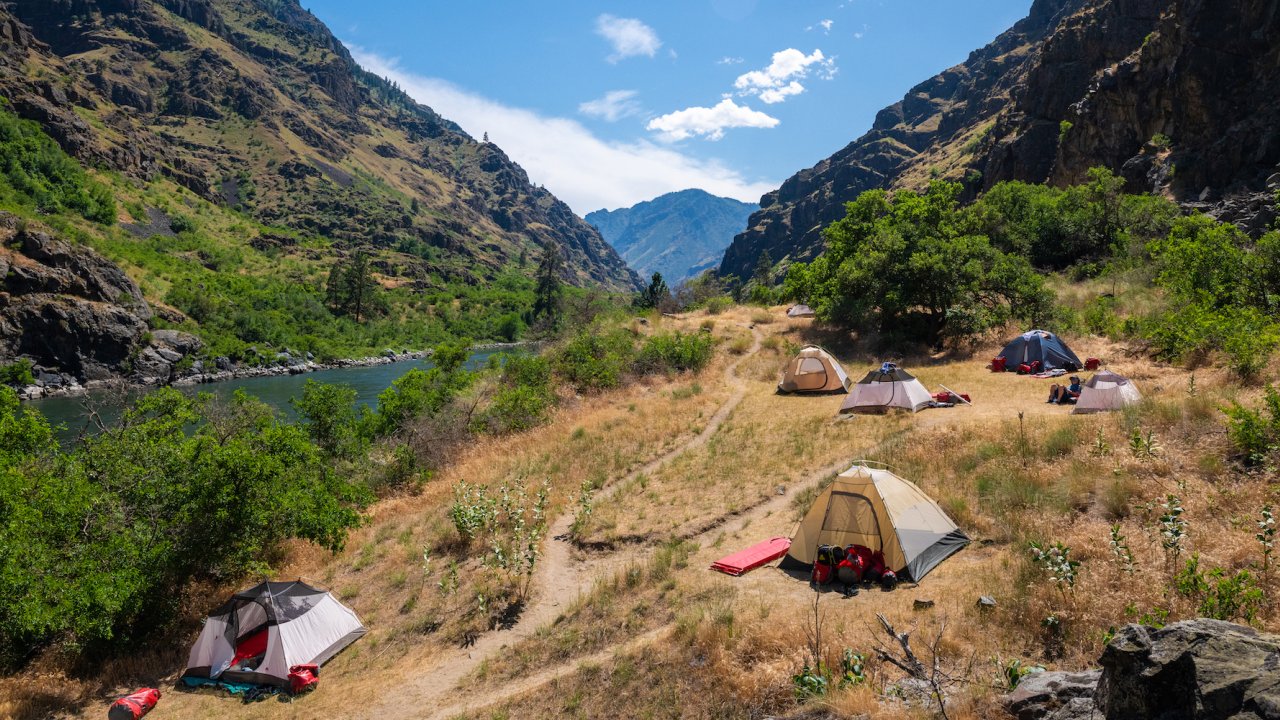 A group of tents set up on a hillside along the Snake River through Hells Canyon