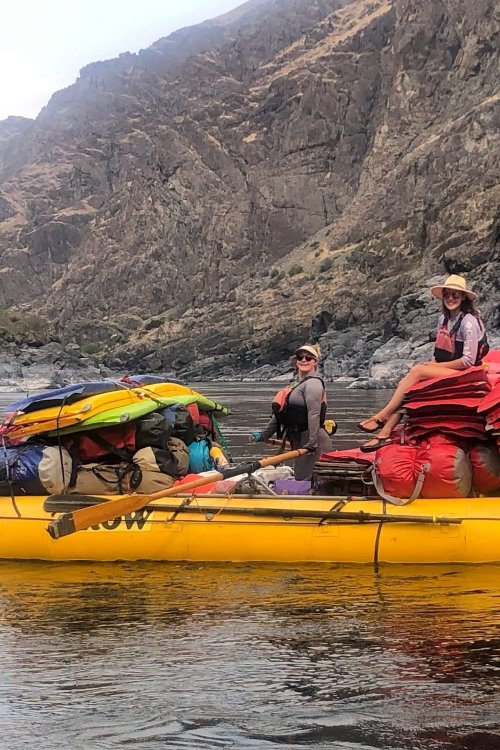 Two river guides floating downstream on a yellow ROW raft.