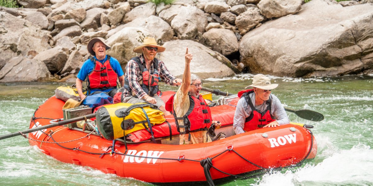 man cheers while white water rafting