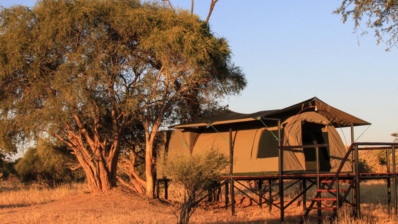 Outside of a canvas style safari tent accommodations.