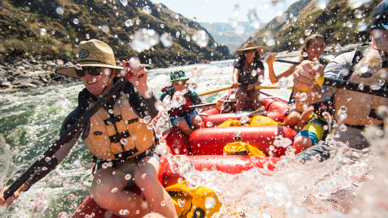 A group of people paddling through a whitewater rapid on the Salmon River Canyons