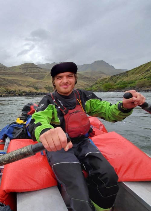 man rowing a raft down a river