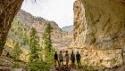 Rafters exploring a massive rock canyon on a hiking excursion during a Middle Fork Salmon River rafting trip in Idaho.