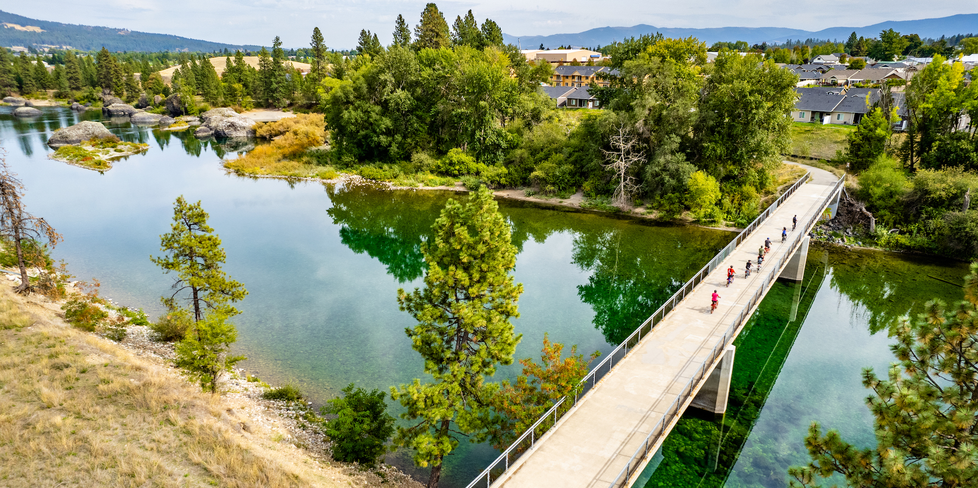 Drone shot of bikers pedaling across a bridge on the Washington-Idaho Centennial Trail