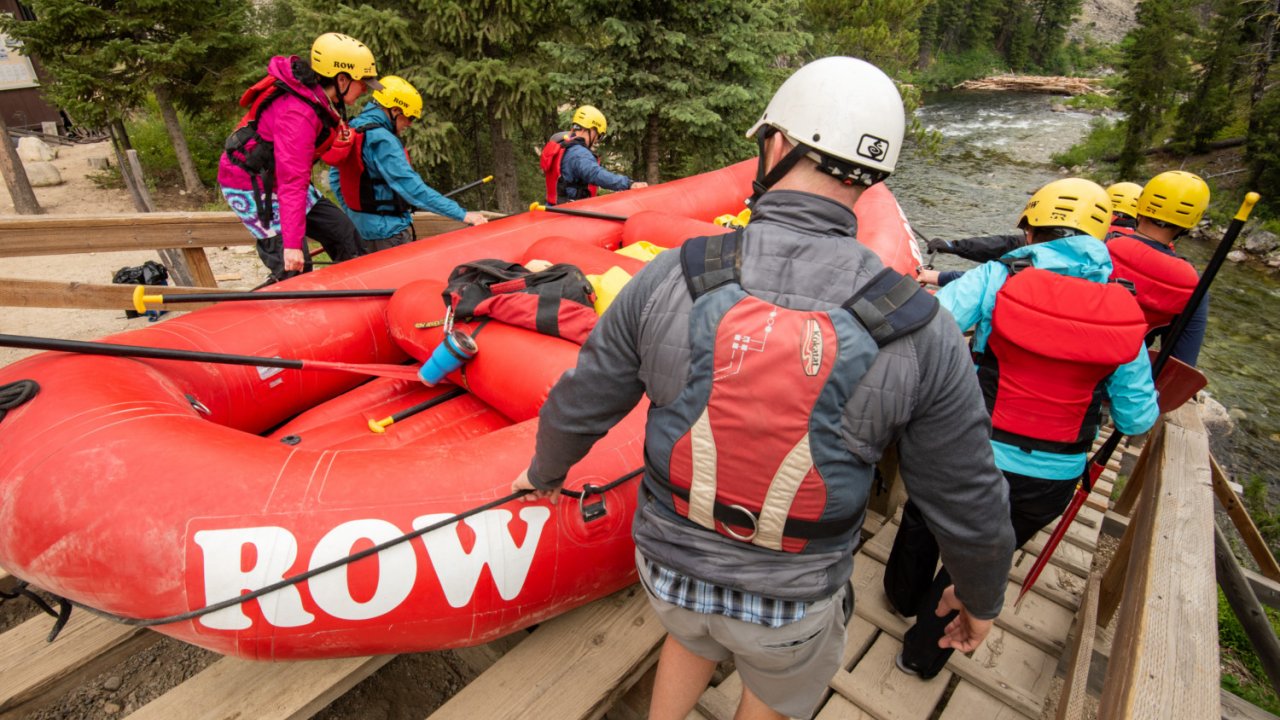 whitwater rafters carrying raft down boat ramp