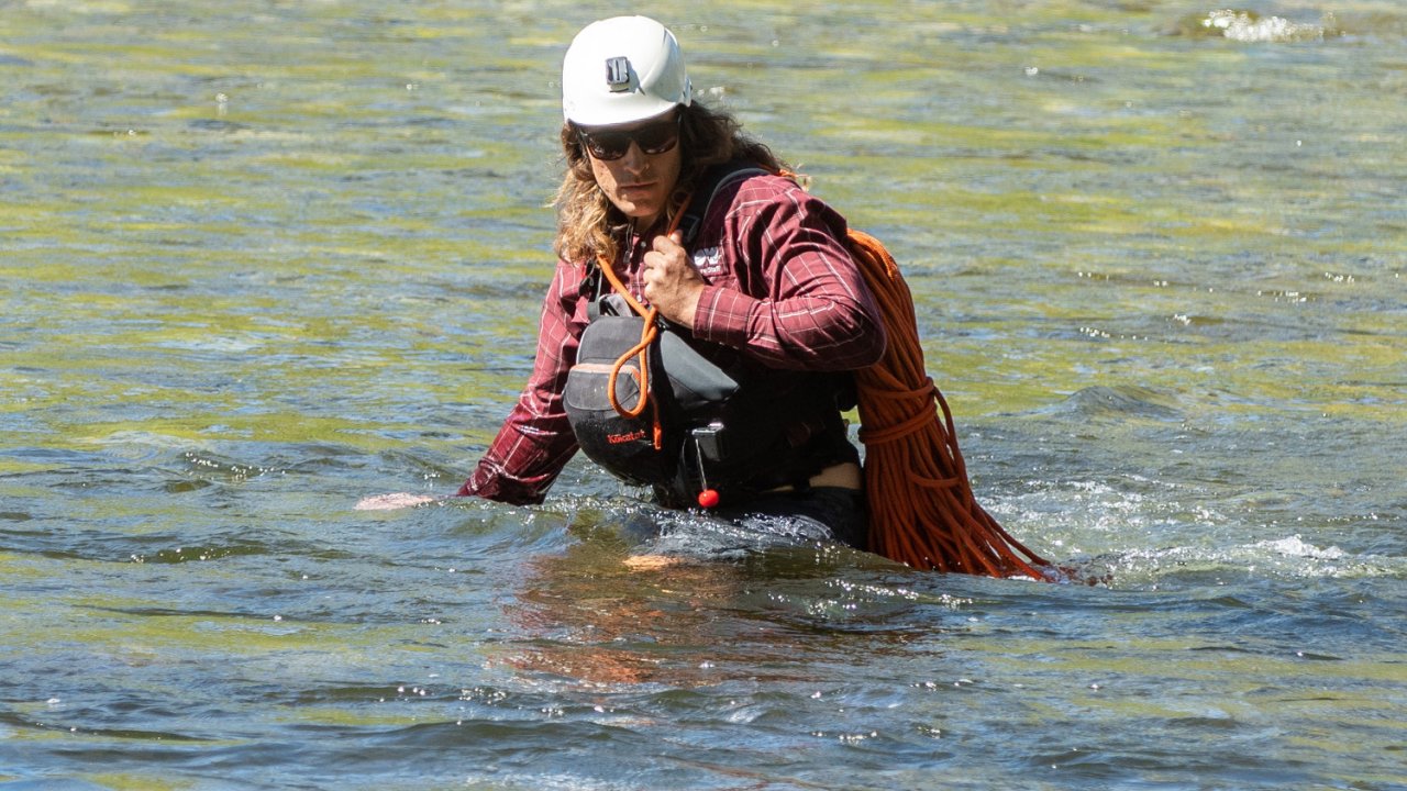 river guide carrying rope in water